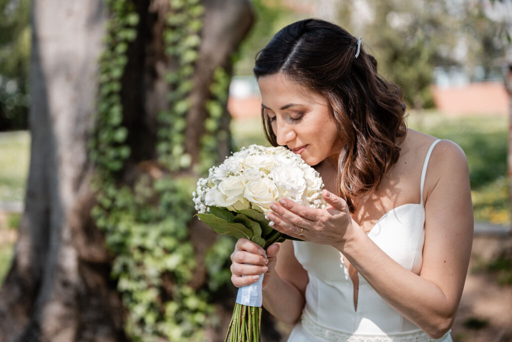 Sposa annusa il suo bouquet nel parco di Villa Litta Modignani, fotografata da Stefano Pedrelli
